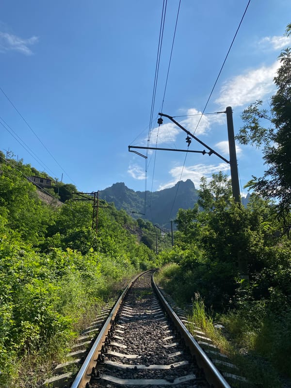 Electrified railway curves through green terrain in Alaverdi