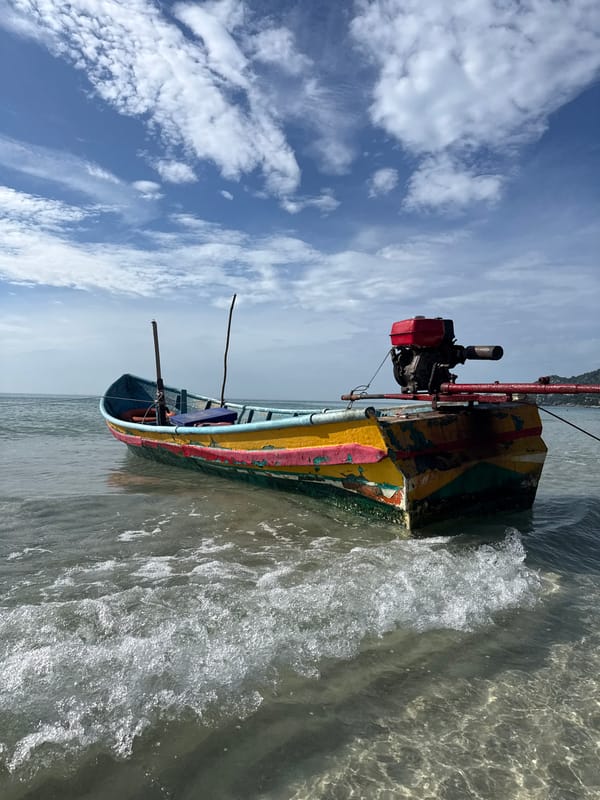 Colorful fishing boat resting in shallow Ko Samui waters