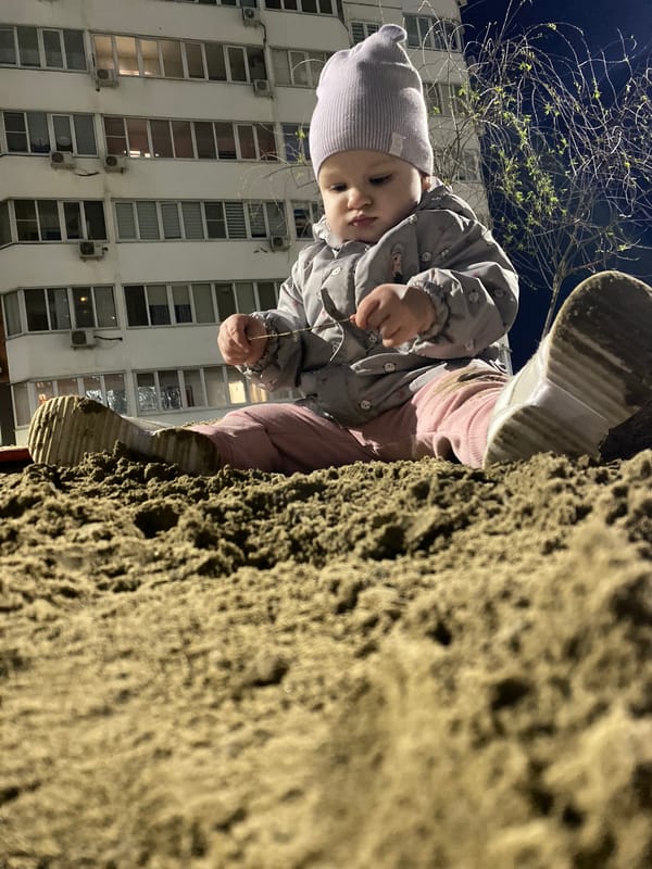 Child plays at urban playground near apartment buildings