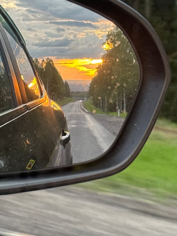Sunset road view captured in car mirror near Russian quarry