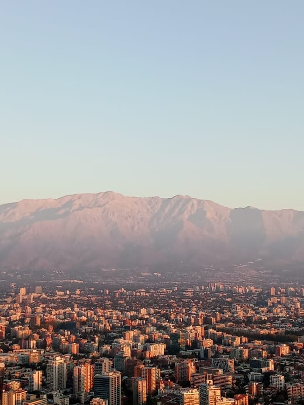 Santiago skyline captured against snow-capped mountains at golden hour