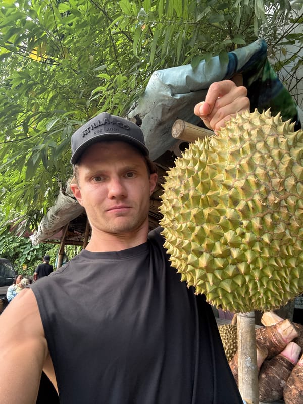 Man handles durian fruit at Indonesian market stall