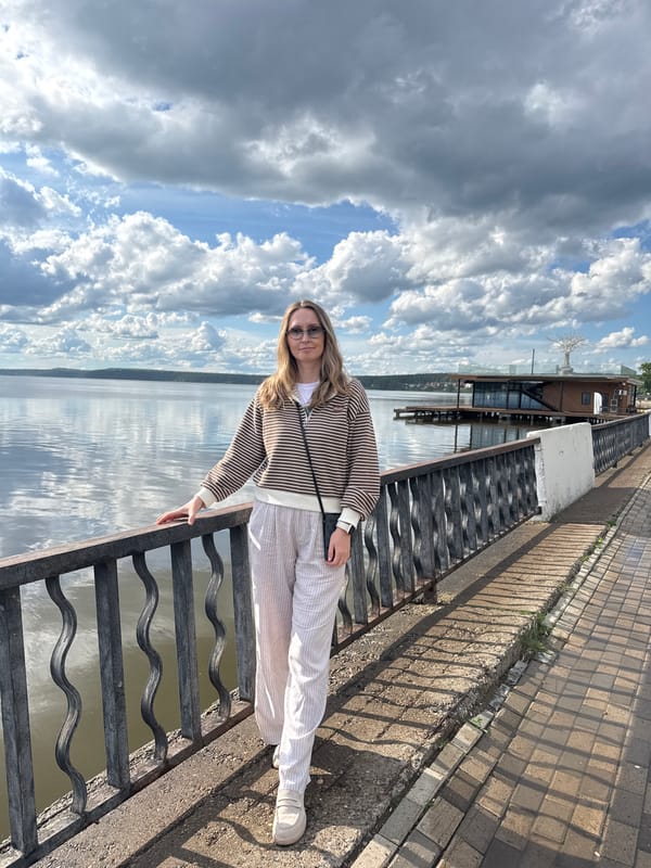 Woman visits military displays along Votkinsk waterfront on cloudy day