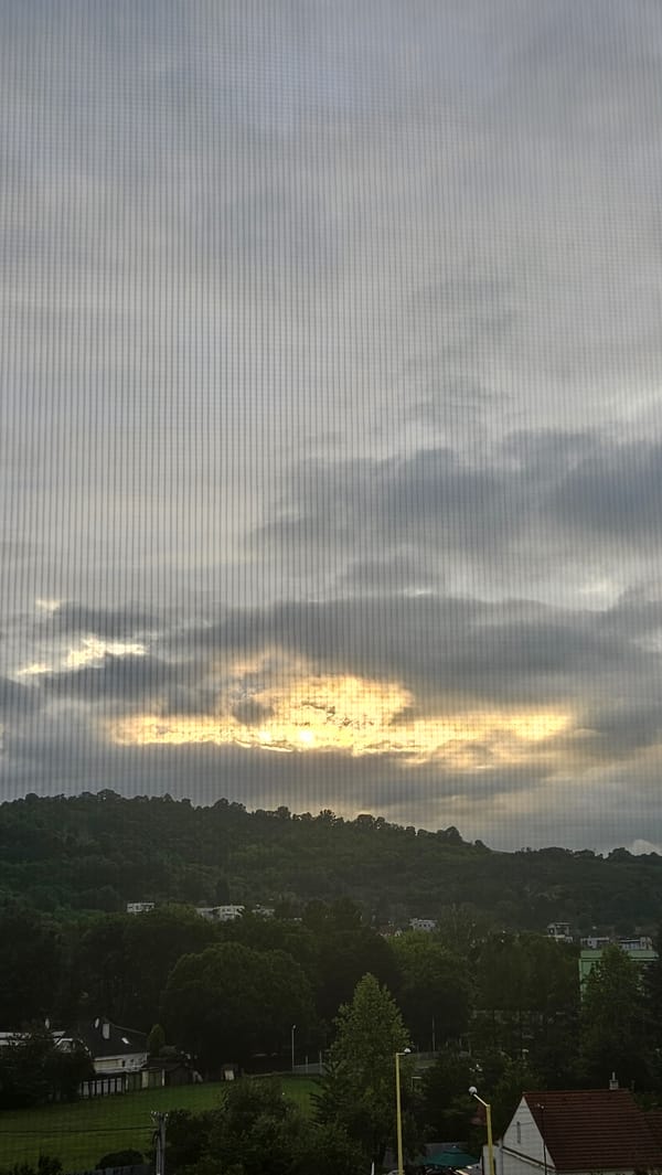 Witness captures sunset landscape view through window in Prešov