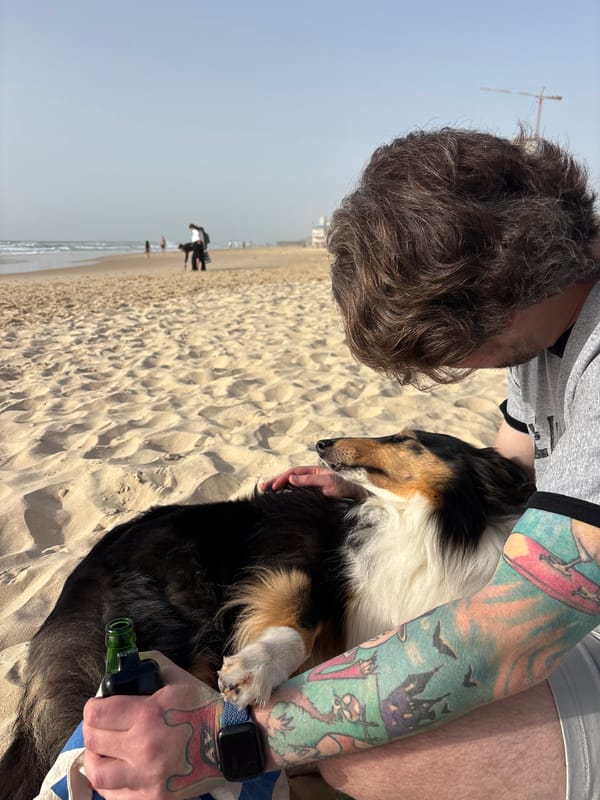 Man embraces dog on Bat Yam beach