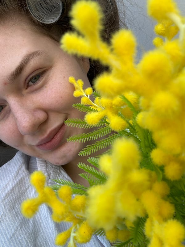 Woman poses with mimosa flowers in Kazan selfie session