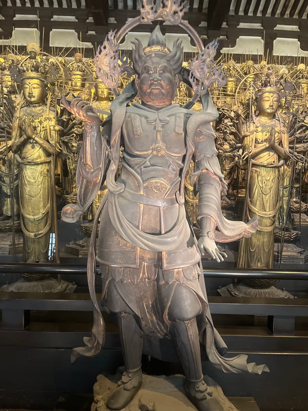 Tourists explore famous Buddhist temple statues in Kyoto
