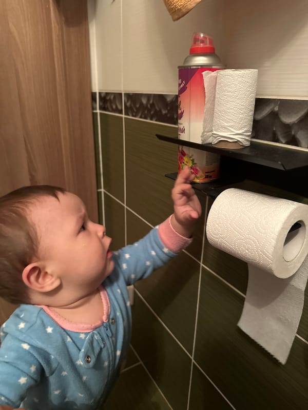 Baby in star pajamas plays with a slinky on the floor