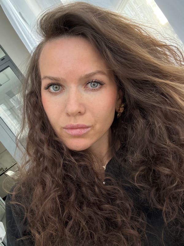 Woman with curly brown hair photographed in indoor workspace