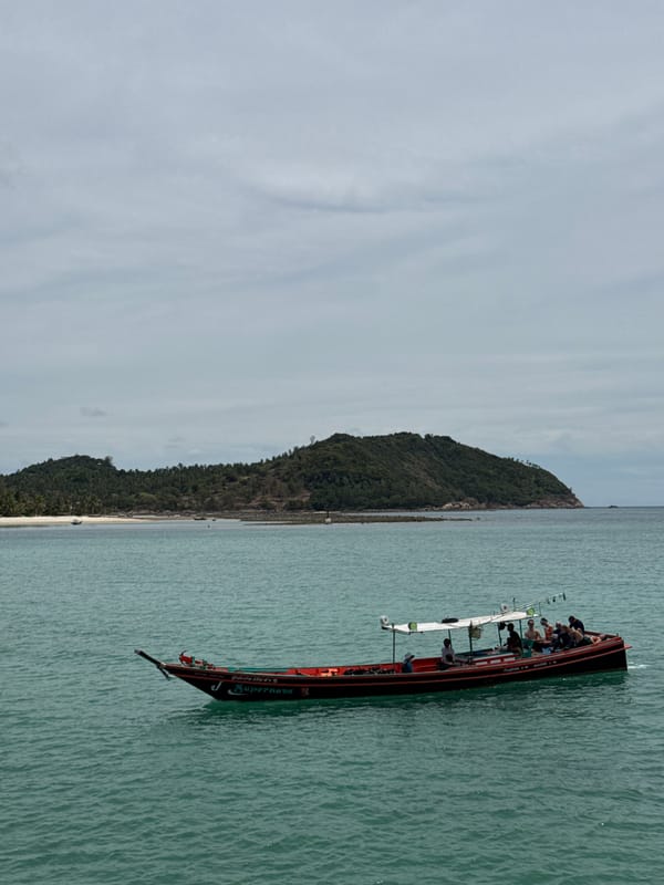 Koh Phangan shoreline with longtail boats and turquoise water