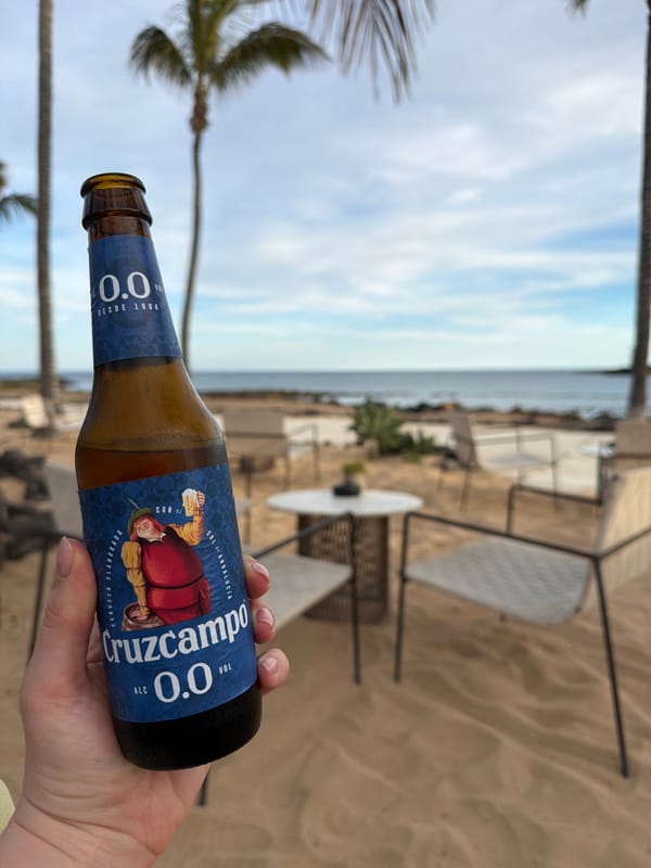 Person enjoys alcohol-free beer at Teguise coast during afternoon