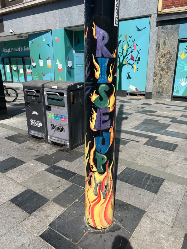 Spring street scenes documented in Slough include graffiti, blooming shrubs