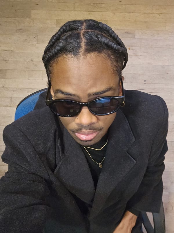 Man in sunglasses sits on blue chair indoors in Paris
