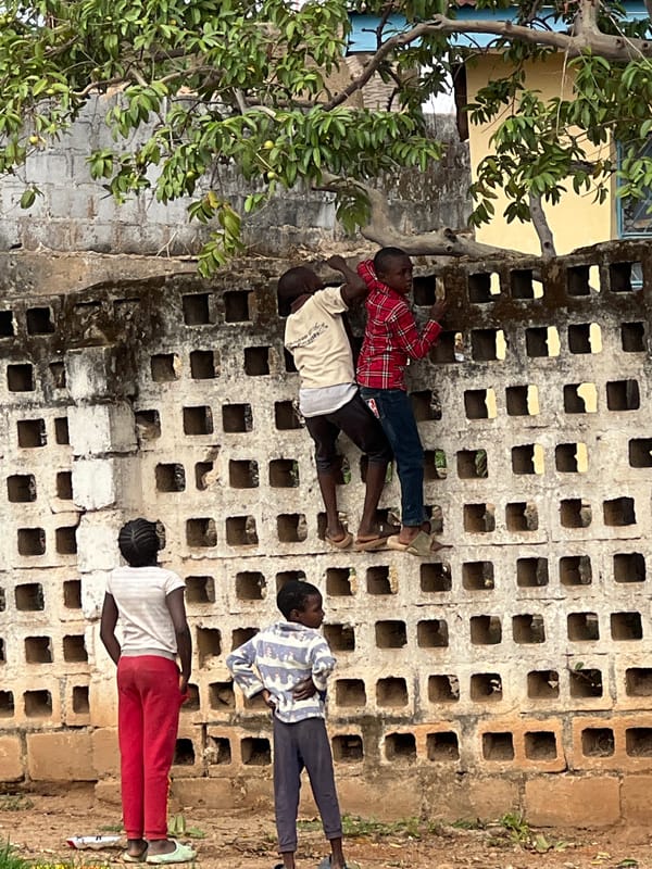 Four children gather along concrete wall in Jos