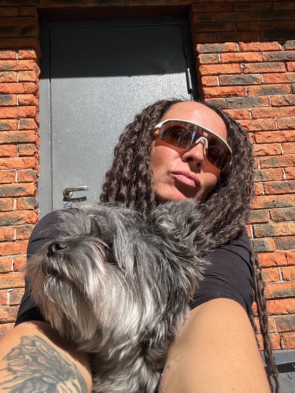 Person with dreadlocks relaxes with dog in Chaikovsky park