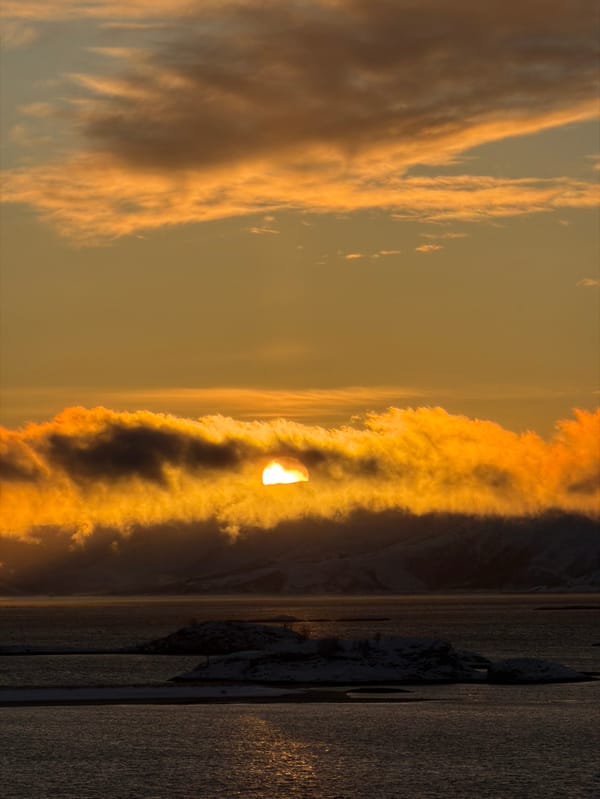Arctic sunset illuminates snow-covered islands near Tromsø, Norway