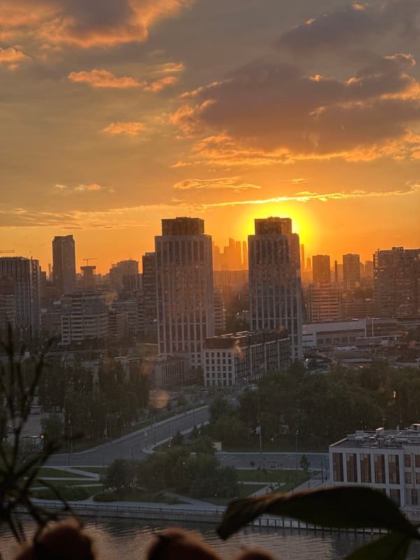Moscow skyline glows warm as the sun sets behind downtown buildings.