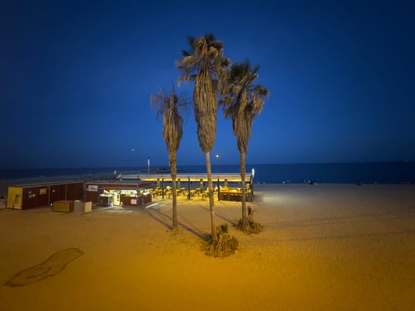 Full moon rises over Barcelona's beach bars at dusk