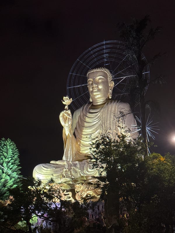 Golden Buddha statue illuminated at night in Đà Lạt
