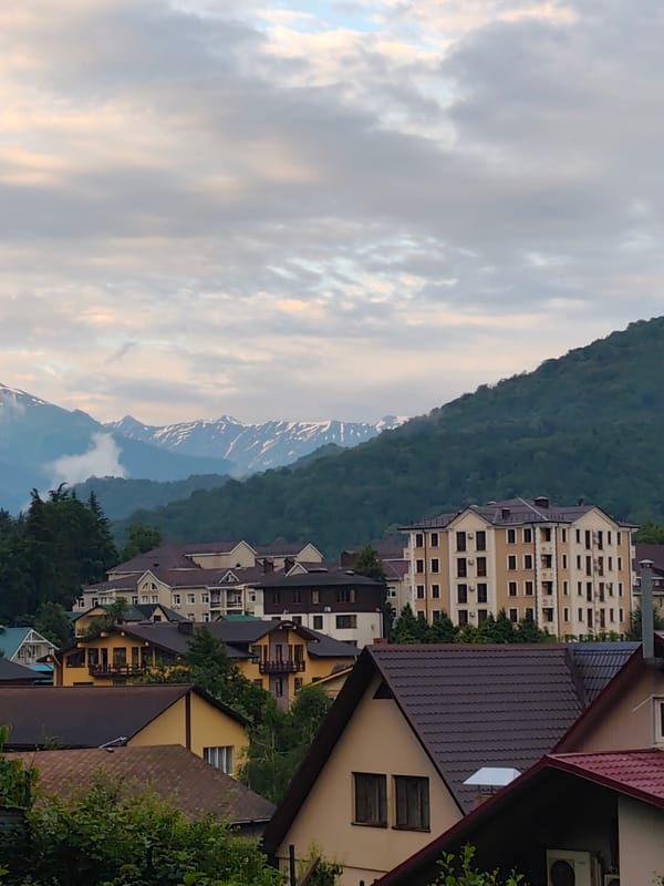 Krasnaya Polyana village framed by snow-capped Caucasus peaks at dusk