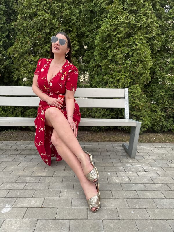 Woman in red dress discards Coca-Cola can in Riga park