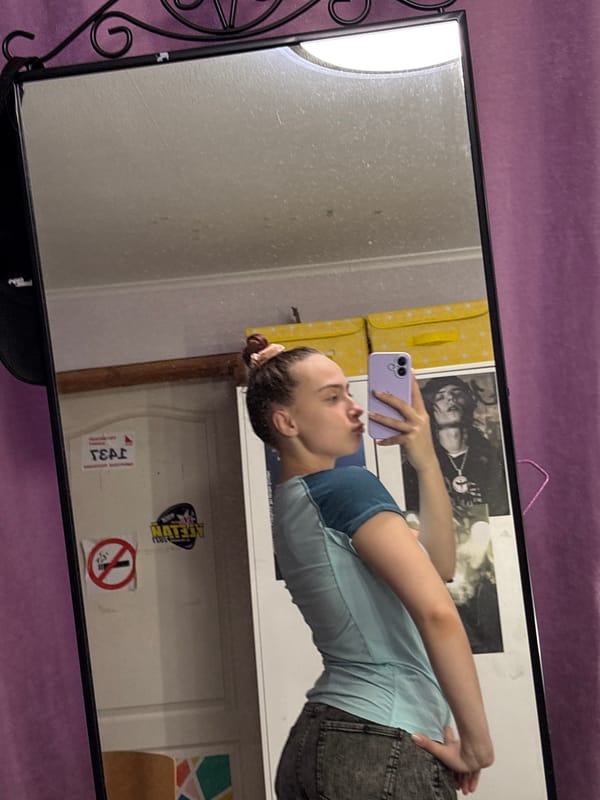 Person takes mirror selfie with purple phone in Russia