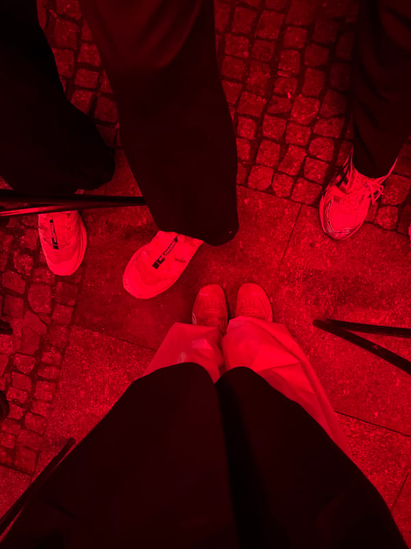 Red-lit nighttime gathering documented across multiple indoor-outdoor venues