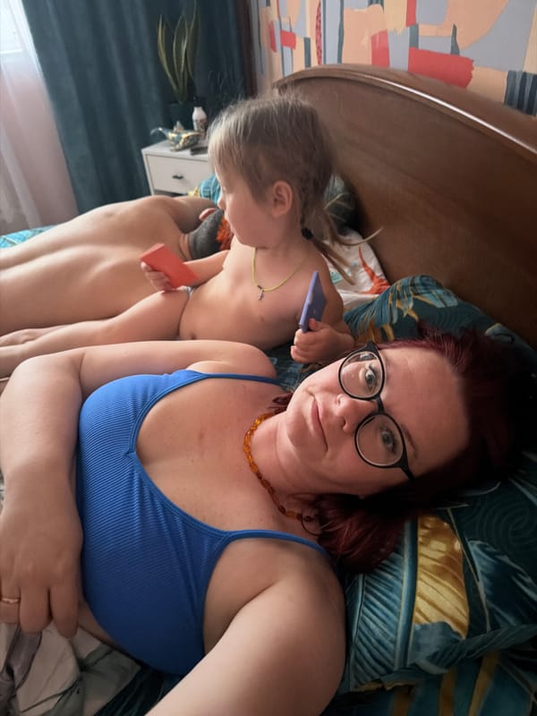 Woman and child share quiet moment on bed in Chaikovsky