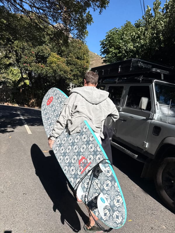 Surfer loads equipment at Hout Bay parking area