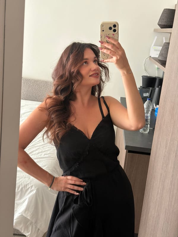 Woman in black dress photographed indoors in Athens