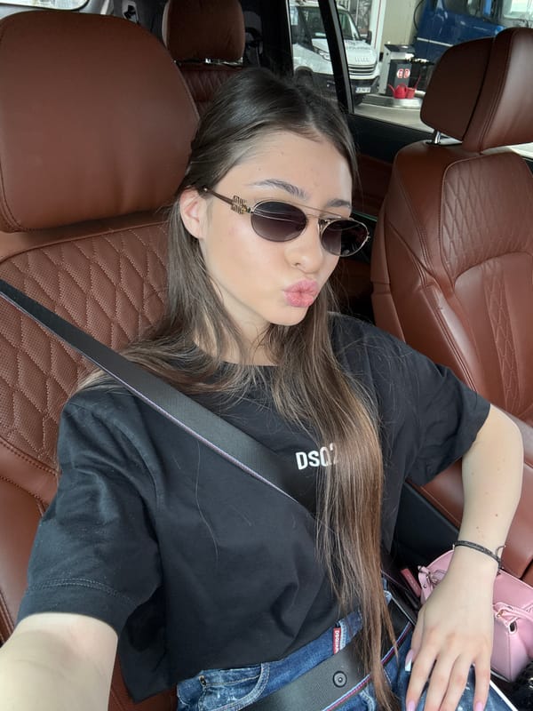 Woman rests in passenger seat wearing designer clothing in Bulgaria