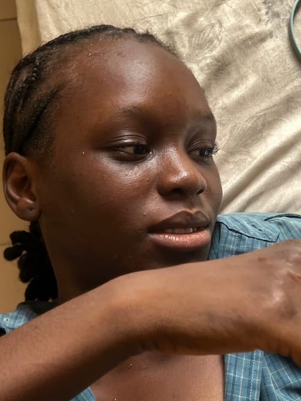 Person photographed resting on bed in Howayi, Nigeria