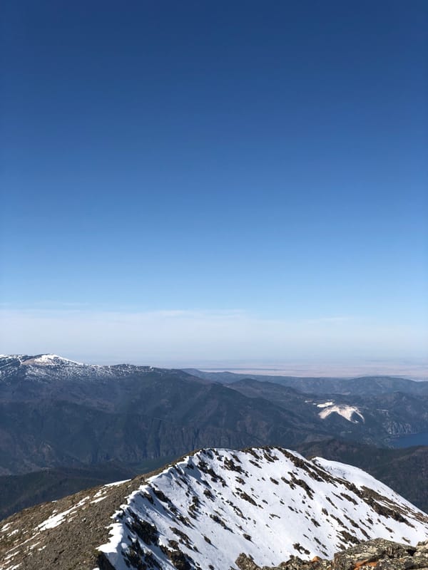 Snow-covered mountain slopes observed under clear skies in Sayanogorsk