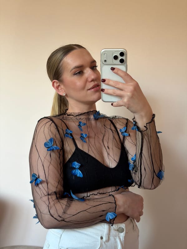 Woman takes mirror selfies in yellow top and sunglasses