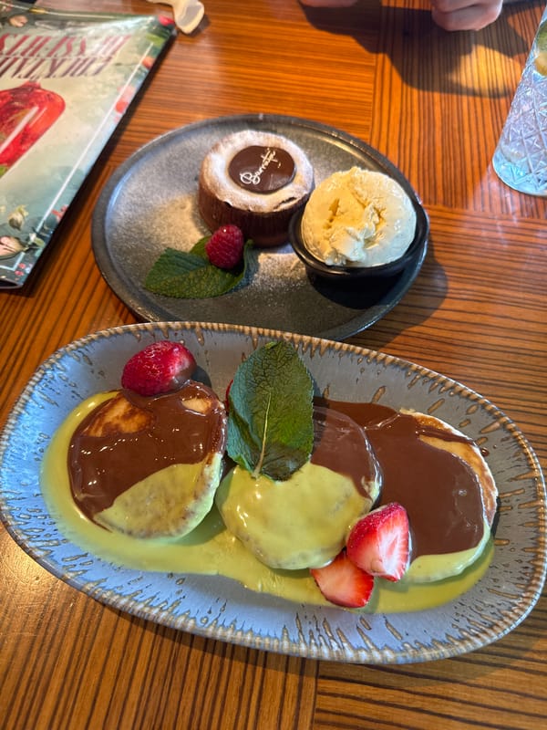 Soufflé pancakes and iced cocktails on a wooden table