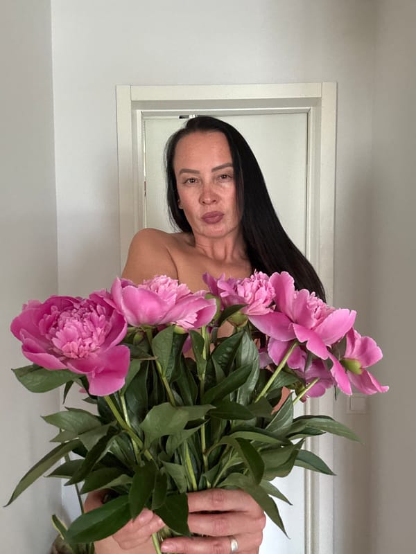 Woman poses with pink peonies in Chaikovsky, Russia