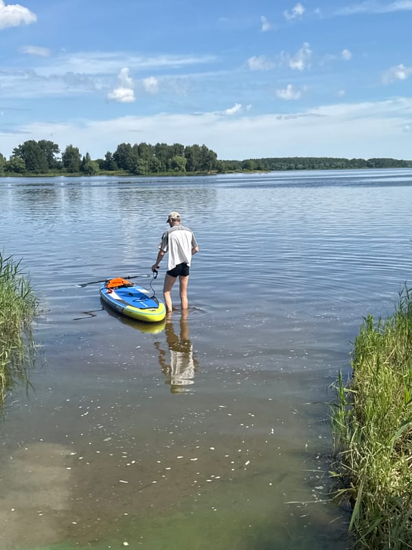 Stand-up paddleboarding on calm open water at dawn