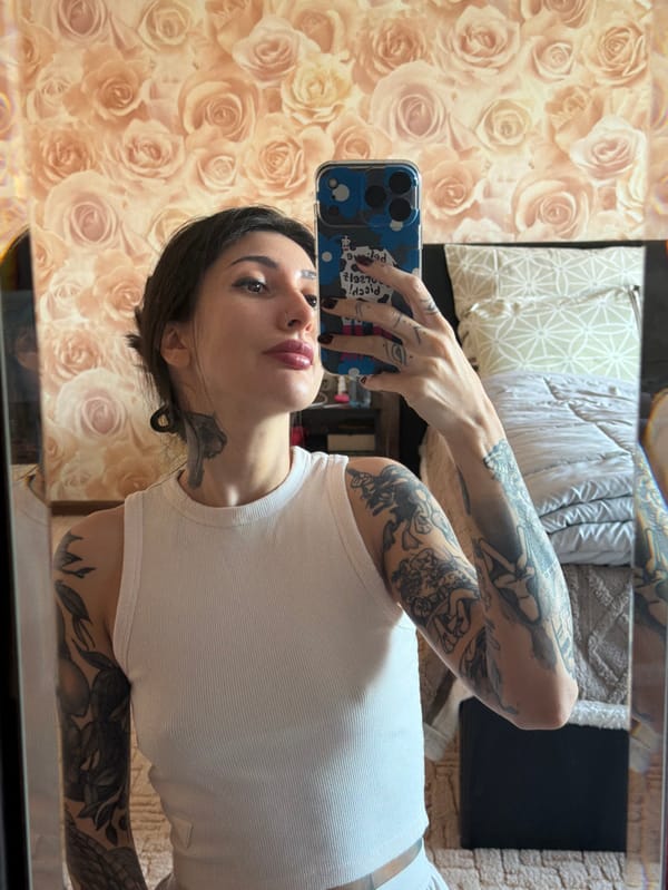 Tattooed woman captures mirror selfie with phone