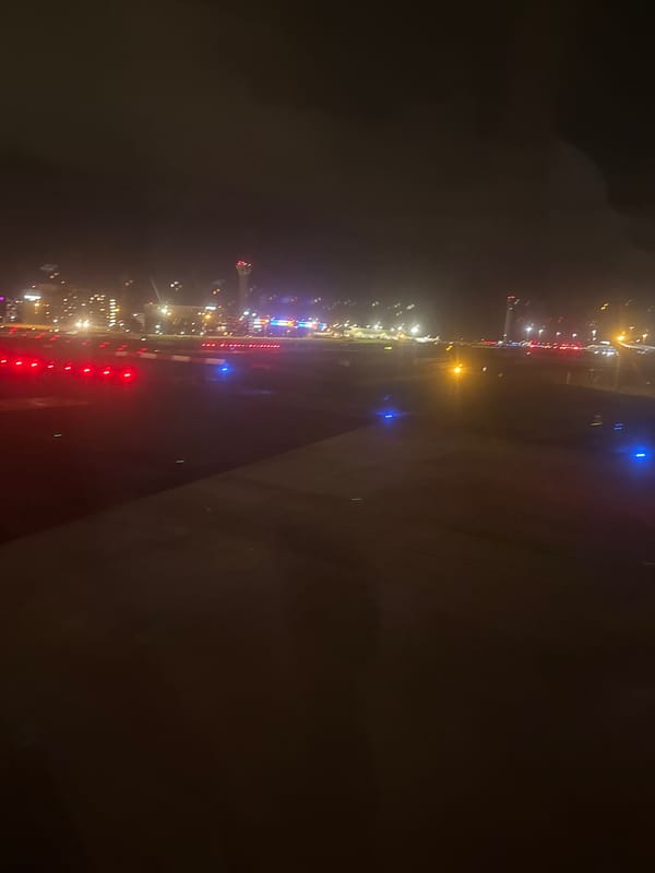 Nighttime aerial view of illuminated airport from airplane window