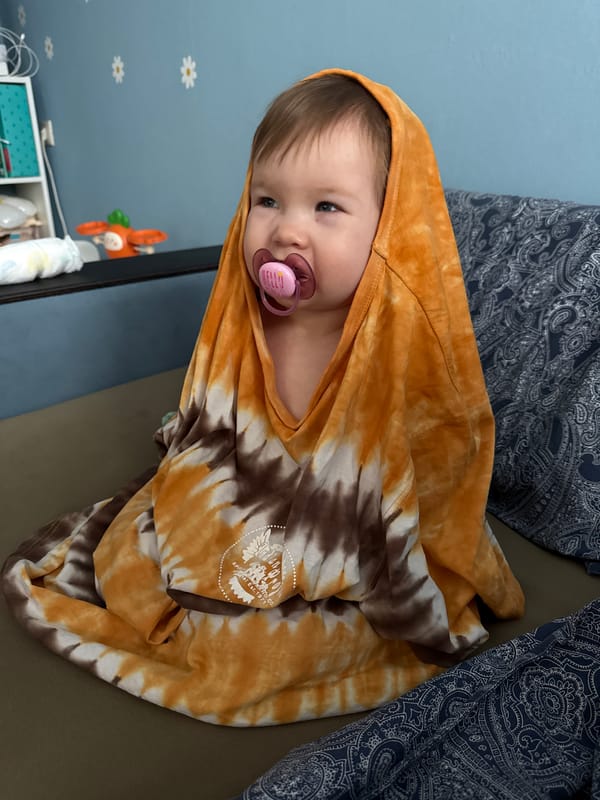 Child in tie-dye hoodie rests on couch in Moscow