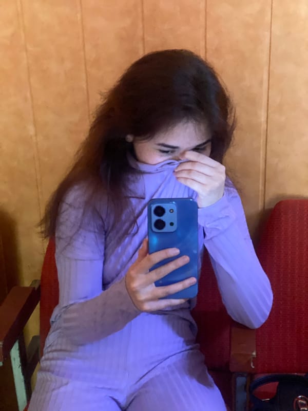 Two people documented indoors with phone, pole in Poltava