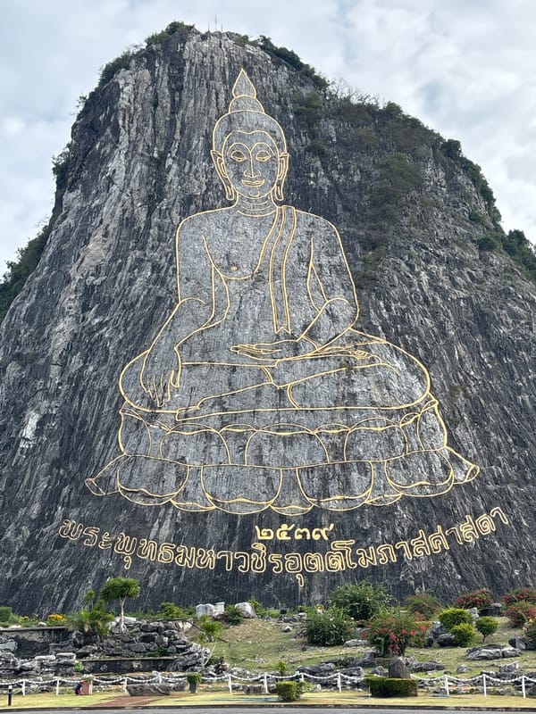 Gold-outlined Buddha carved into rocky hillside in Bang Sare