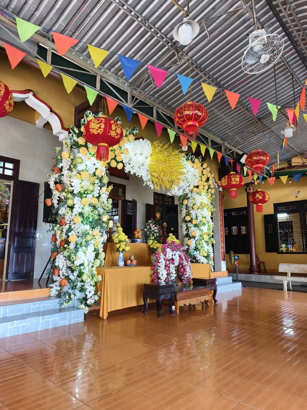 Decorated temple interior with flower archways and colorful ceremonial displays