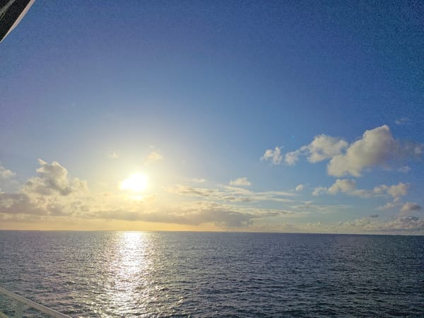 Calm seas and offshore oil platform observed under evening sky