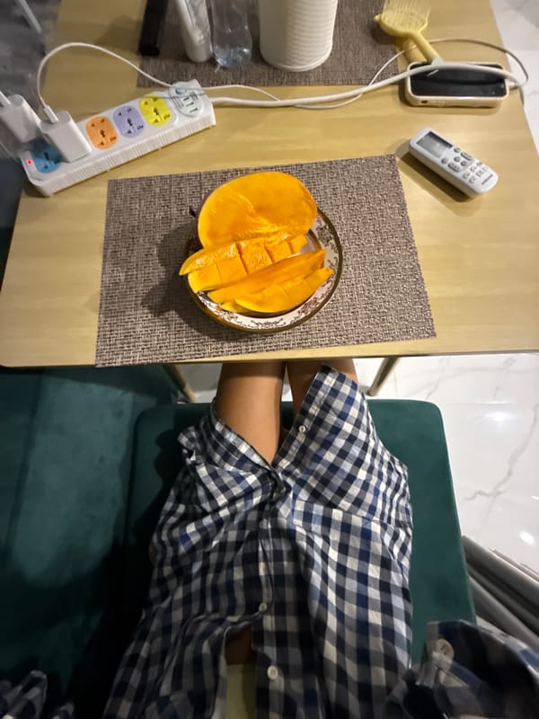 Chilling at home in Khan Mean Chey with mangoes and a phone