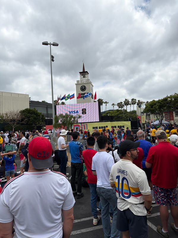 Crowd gathers around a large outdoor screen in LA