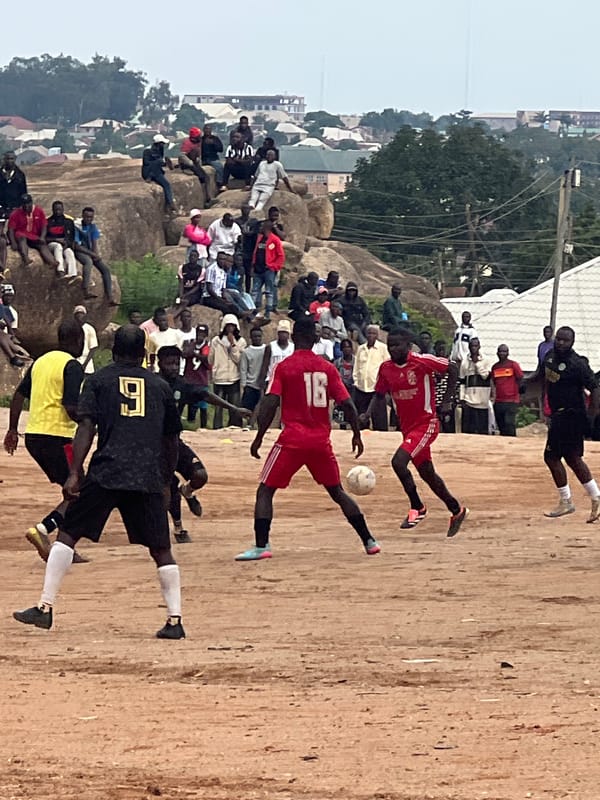 Pickup football match on a rocky dirt field in Jos, Nigeria
