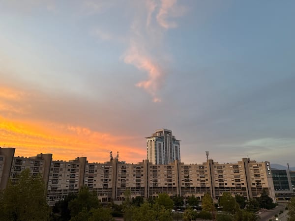 City skyline glows under a warm sunset sky.