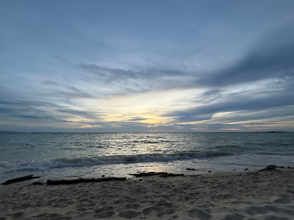 Koh Phangan beach at dusk, clouds stacked above a fading horizon