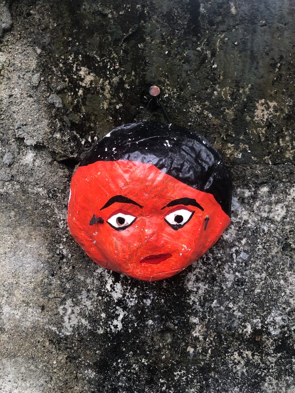 Handmade papier-mâché mask photographed on ground in Kabalana, Sri Lanka